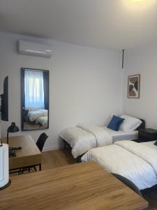 a room with two beds and a table and a mirror at MW 4A Apartament in Rzeszów