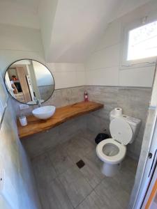 a bathroom with a toilet and a sink and a mirror at FloreSer in Villa Gesell +6 photos