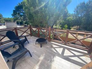 a patio with two chairs and a table and a fence at FloreSer in Villa Gesell
