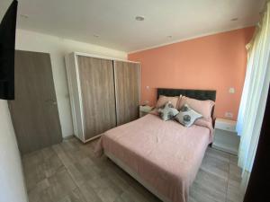 a bedroom with a pink bed with two pillows at FloreSer in Villa Gesell