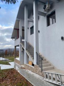 a white building with stairs on the side of it at Lakeview Apartment & Spa in Belosavci