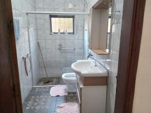 a small bathroom with a sink and a toilet at Aconchego de mae - 5 min do Santuário e comércios - Casa completa in Aparecida +12 photos