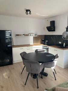 een keuken met een zwarte tafel en een aantal stoelen bij U Mariki 