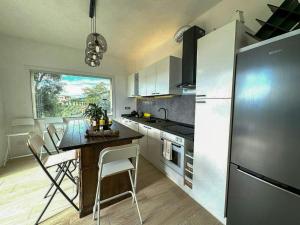 una cucina con tavolo con sedie e frigorifero di Panoramic Villa In The Lucca Hills a Capannori Altre 32 foto