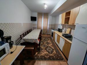 a small kitchen with a table and chairs in it at Casa Bucovina Dorna Candrenilor in Ascuţitele