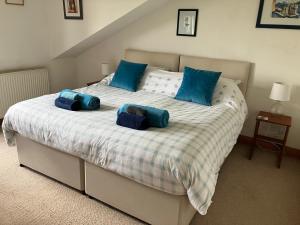 een slaapkamer met een groot bed met blauwe kussens bij Midkinleith Farm Holiday Cottage in Edinburgh