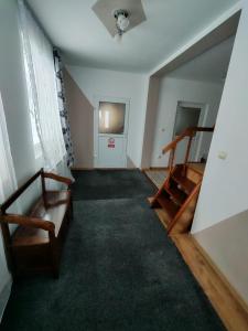 an empty room with a staircase and a living room at Casa Bucovina Dorna Candrenilor in Ascuţitele