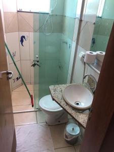 een badkamer met een toilet, een wastafel en een douche bij FlatsRose CH Flamboyant Conforto e qualidade in Goiânia