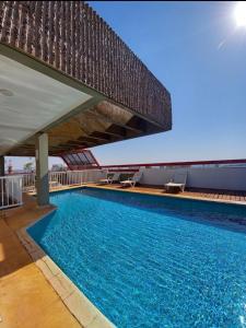 a large swimming pool under a large building at Flat central com estacionamento in Ribeirão Preto