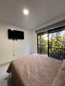 een slaapkamer met een bed en een flatscreen-tv bij El Lago in Coronado