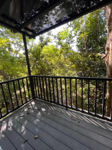 een houten terras met een zwarte leuning en bomen bij El Lago in Coronado