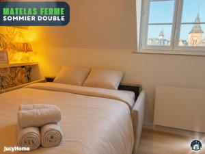 a bedroom with a bed with towels on it at Bleu Horizon in Berck-sur-Mer