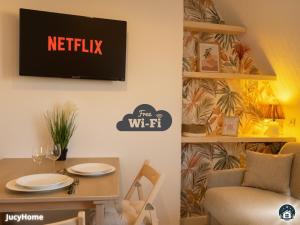 a dining room with a tv on the wall at Bleu Horizon in Berck-sur-Mer