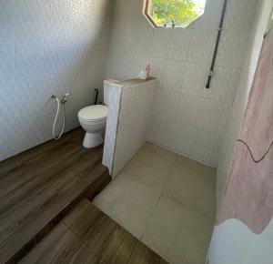 a small bathroom with a toilet and a window at Lanina homestay in Ipi