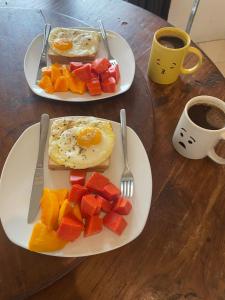 two plates of breakfast food on a wooden table with coffee at Lanina homestay in Ipi +28 photos