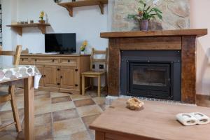 a living room with a fireplace and a tv at Casa rural BUSEO in Chera