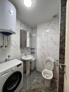 a bathroom with a toilet and a sink and a washing machine at Apartman Luka in Cetinje +4 photos