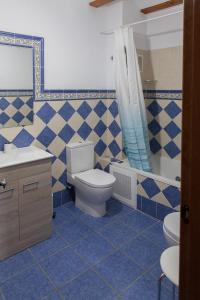a blue tiled bathroom with a toilet and a sink at Casa rural BUSEO in Chera +14 photos