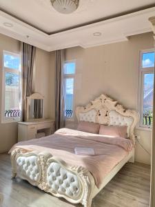 a bedroom with a large white bed with pink pillows at Sa Villa Da Lat in Da Lat