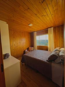 a bedroom with a large bed and a window at Quinta Sol Montês in Rancho Queimado
