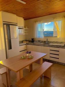 a kitchen with a wooden table and a wooden ceiling at Quinta Sol Montês in Rancho Queimado +19 photos
