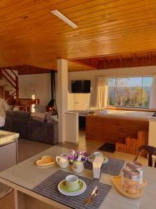 a kitchen and living room with a table with dishes on it at Quinta Sol Montês in Rancho Queimado