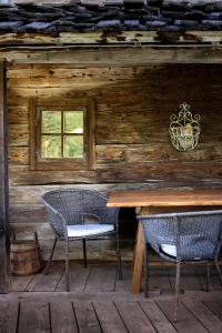 a wooden cabin with a table and two chairs at Chalet Mühlburger in Gruben