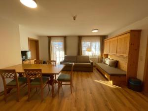 een woonkamer met een tafel en een bank bij Hubertushof Ferienwohnungen in Gerlos