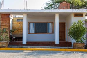 ein weißes Haus mit Säulen und einer Veranda in der Unterkunft Tides Lobitos in Lobitos