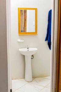 ein Badezimmer mit einem weißen Waschbecken und einem Spiegel in der Unterkunft Tides Lobitos in Lobitos