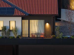 a house with a balcony with a table and chairs at El Cielo - Rooms with Panoramic View & El Carnicero Restaurant in Cornedo Vicentino