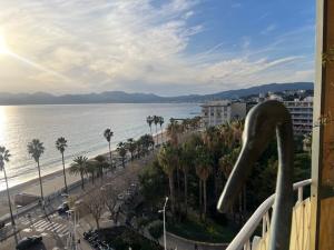 a balcony with a view of the ocean and a beach at Rocamare, la Vie est Belle! in Cannes