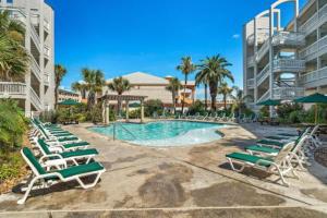 a group of lounge chairs and a swimming pool at Casa Del Mar 231 - Ocean View Family Retreat on Seawall in Galveston