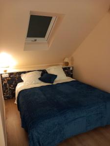 a bedroom with a bed with a blue blanket at Chambre Cosy Eaubonne in Eaubonne