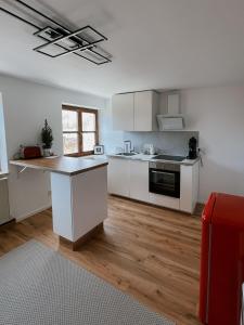una cucina con mobili bianchi e un piano di lavoro di Your Home Base - Vacation & Work close to Munich a Dachau