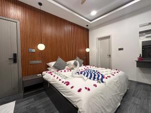 a bedroom with a large bed with red flowers on it at Sea Tides Dhangethi in Dhangethi