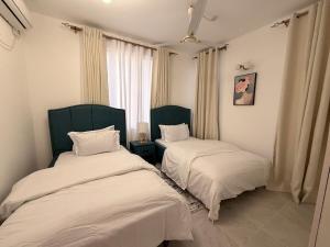 a bedroom with two beds and a window at Kijani Luxury Beach apartment in Malindi +37 photos