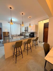 a kitchen with chairs and a counter in a room at Kijani Luxury Beach apartment in Malindi