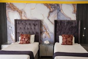 En eller flere senge i et værelse på MATAT GARDENS