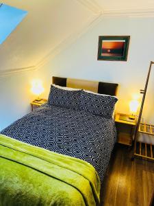 a bedroom with a bed and two end tables with lamps at Pisgah Guesthouse Snowdonia in Blaenau-Ffestiniog