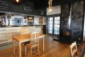 a dining room with a table and a fireplace at Ocean View Bar & Rooms in Laide +26 photos