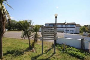 a street sign in the grass next to a street light at Ocean View Bar & Rooms in Laide