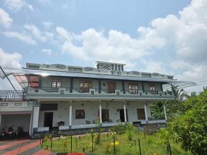 a large white building with a lot of windows at Annai Agham in Kankesanturai