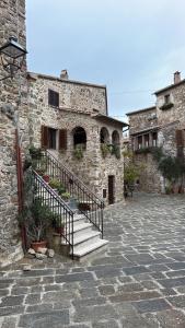 a stone building with stairs in front of it at Casa Pruno Rosso in Montemerano