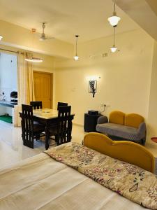 a dining room and living room with a table and chairs at Pitambar in Varanasi