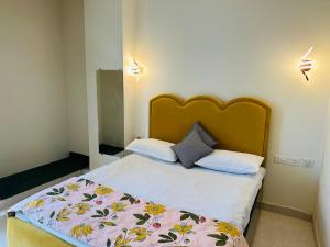 a bedroom with a bed with a floral bedspread at Pitambar in Varanasi