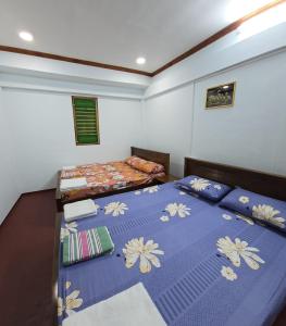a bedroom with two beds with blue comforter at Annai Agham in Kankesanturai