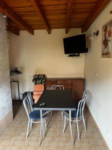 a dining room table with chairs and a flat screen tv at Domek Sabrinka in Słajszewo
