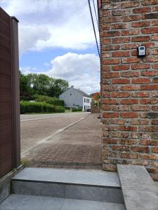 a brick wall with an open door on a street at Le 8 du Pontois in Ciney