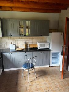 a kitchen with a chair and a white refrigerator at Domek Sabrinka in Słajszewo